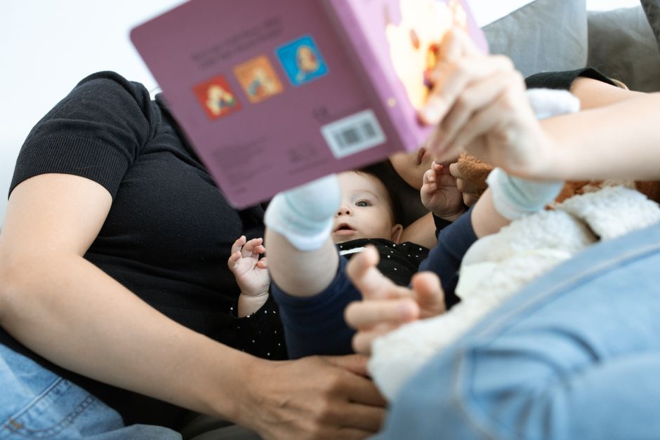 Aile, bebekle birlikte kitap okuyor ve sakinleşiyor.