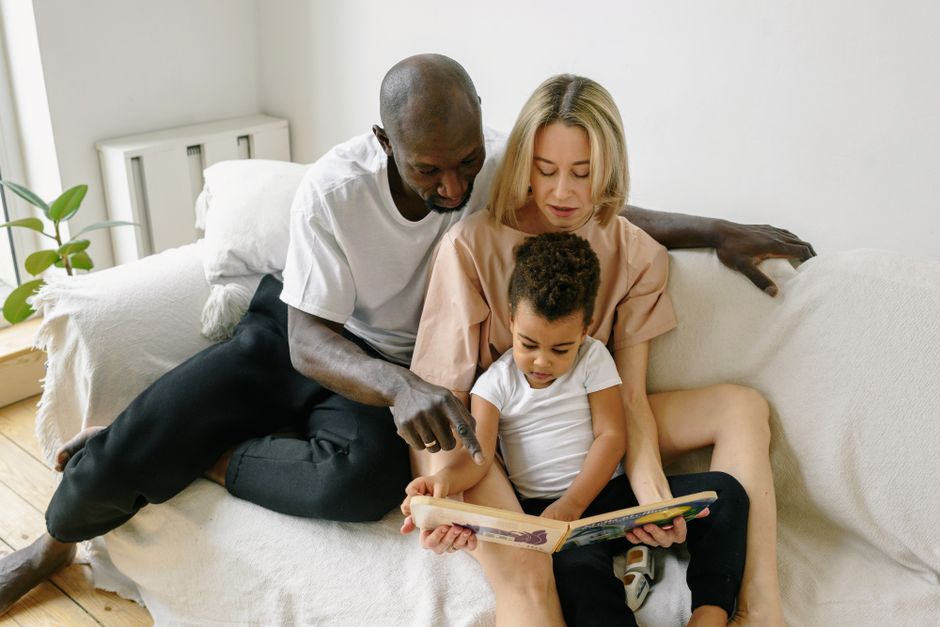 Aile birlikte evde oturmuş kitap okuyor ve sohbet ediyor